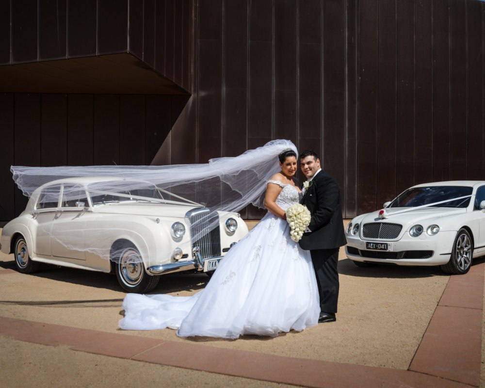 Bride and Groom with wedding cars